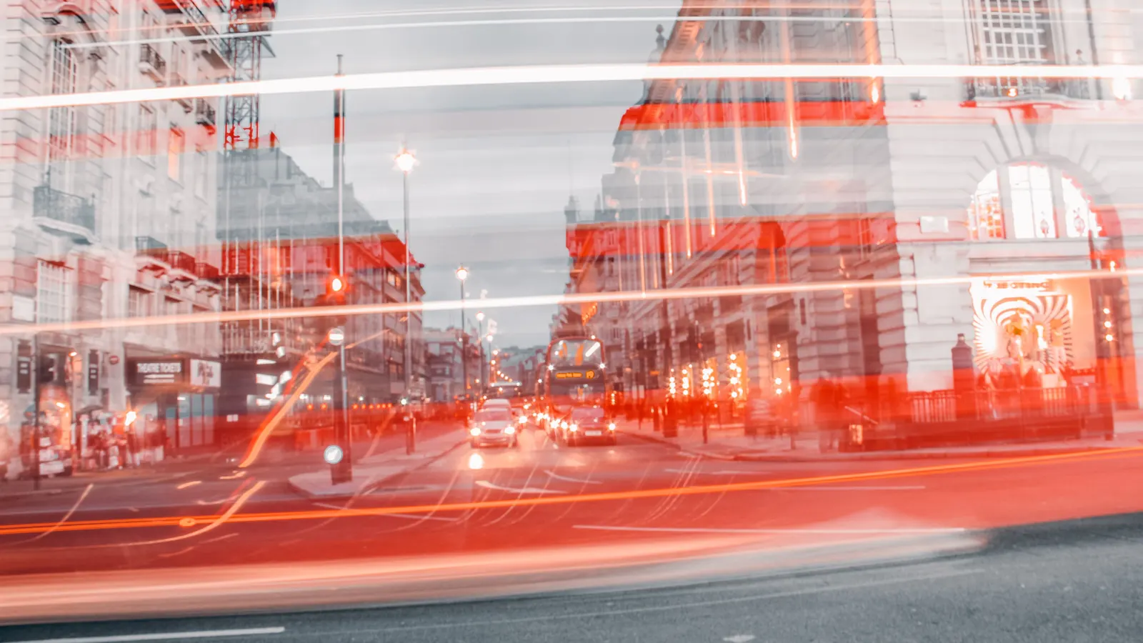 A long-exposure night photo of red light trails on a city street